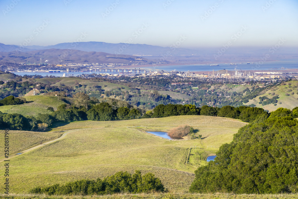 Green rolling hills in Briones Regional Park and Pollution over Suisun Bay in the background, Contra Costa county, San Francisco east bay, California