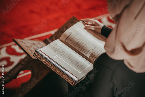 Musliim girl reading Quran in mosque photo