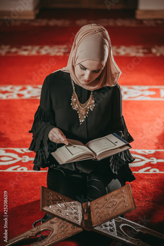 Musliim girl reading Quran in mosque photo