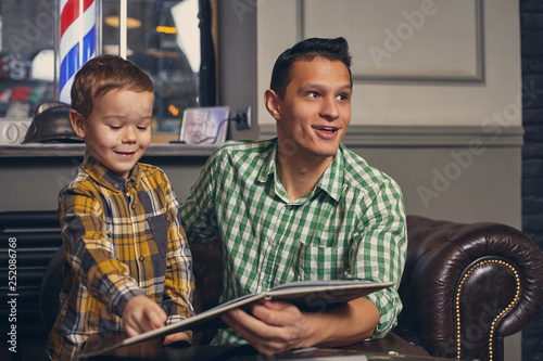 Wallpaper Mural Young father and his stylish little son in the barbershop in the waiting room. Torontodigital.ca