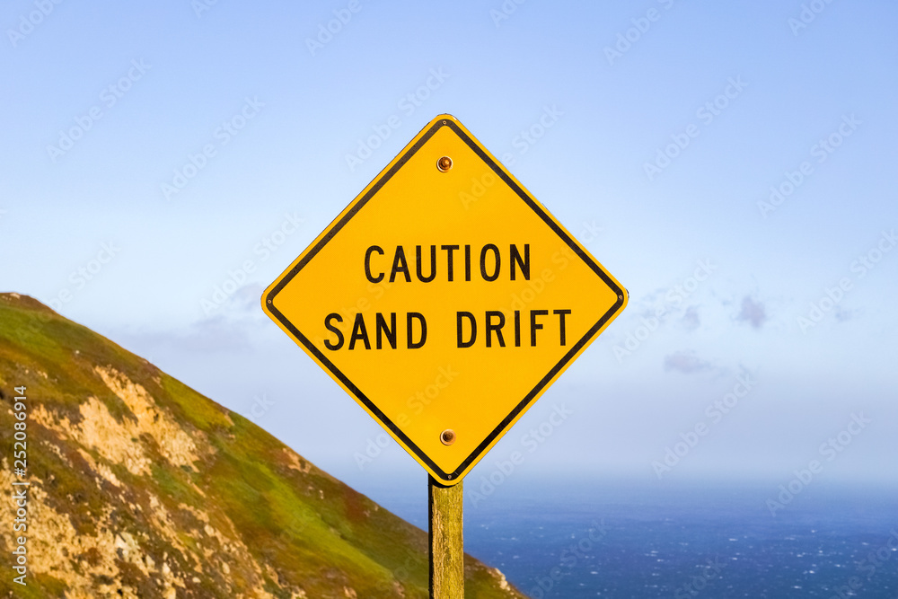 Sand drift sign on the Pacific Ocean Coast, California