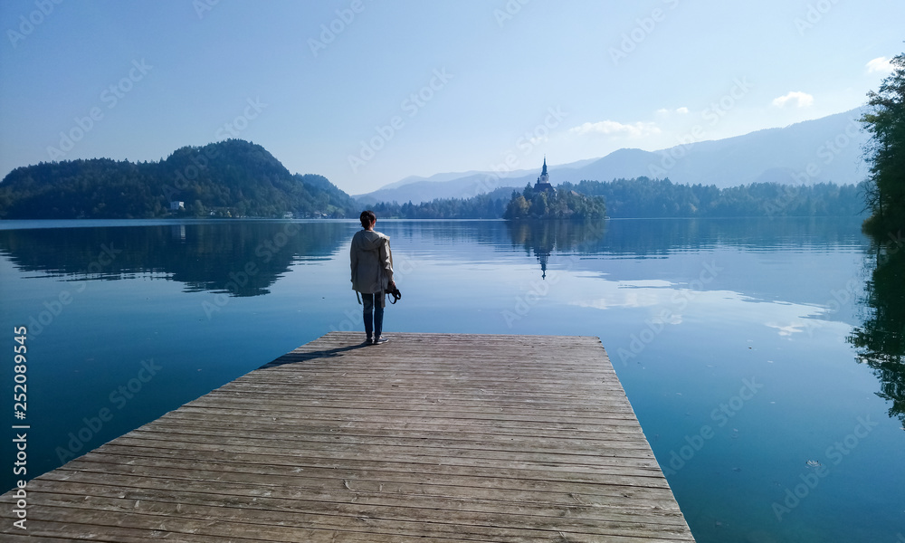 Girl  looking at lake Bled from wood bridge, Slovenia