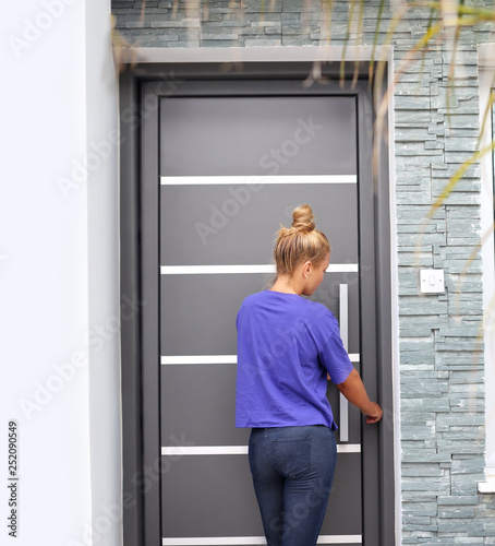 Beautiful woman opening the door of her home.Woman entering the house