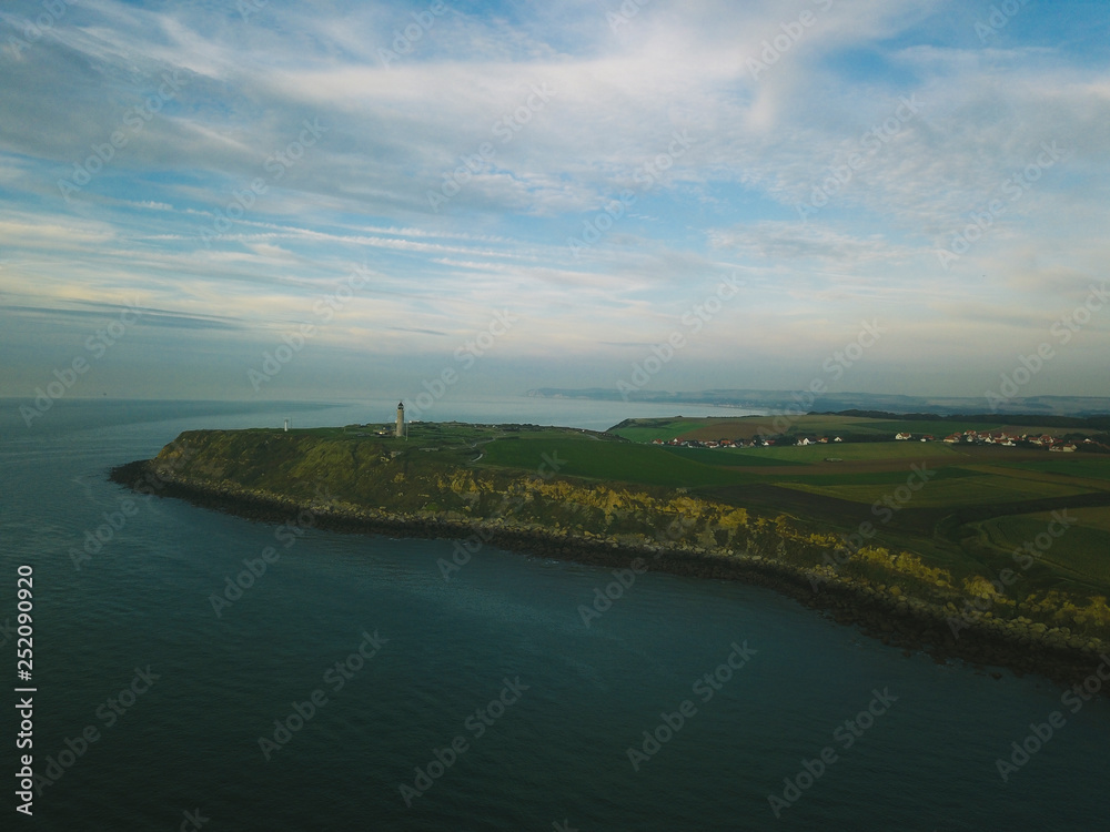 Fototapeta premium green plain with a view of the lighthouse.