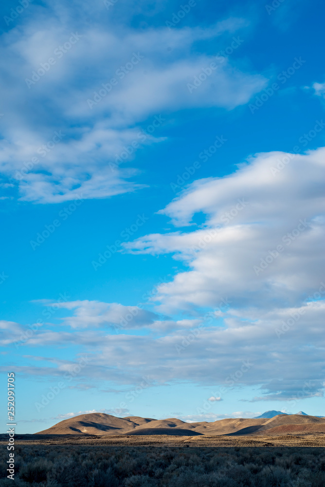 blue sky white clouds over desert hills landscape Eastern Sierra Nevada mountains