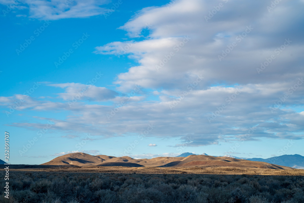 blue sky white clouds over desert hills landscape Eastern Sierra Nevada mountains