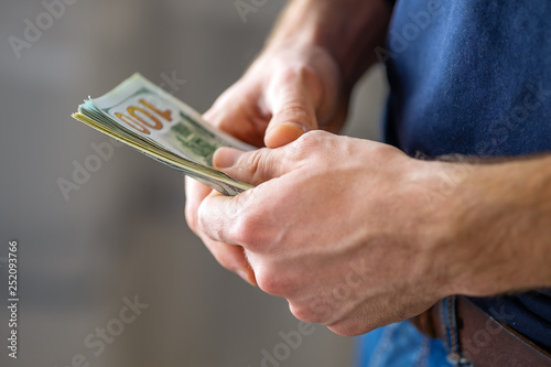 Male hands with banknotes close up. One hundred dollar bills. 