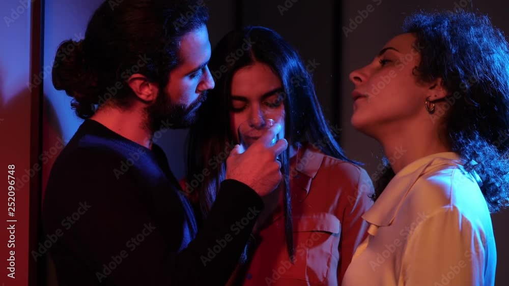 Three people drinking,flirting in the dark night club.Polygamy, threesome Three people drinking,flirting in the dark night club.Polygamy, threesome