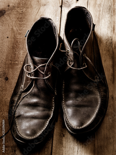 Unlaced men's boots on wood floor photo