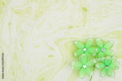 Spring background with green flowers on green textured watercolor paper
