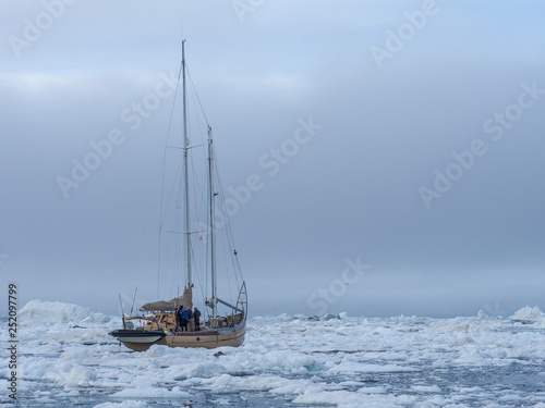 Yacht in the middle of arctic ice floes photo