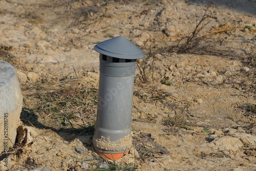 small gray metal pipe chimney in gray ground