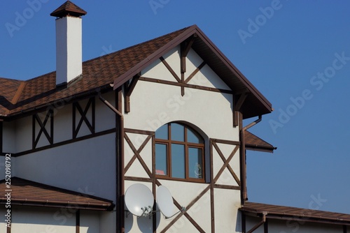 gray loft with window and brown tile on the roof against the blue sky