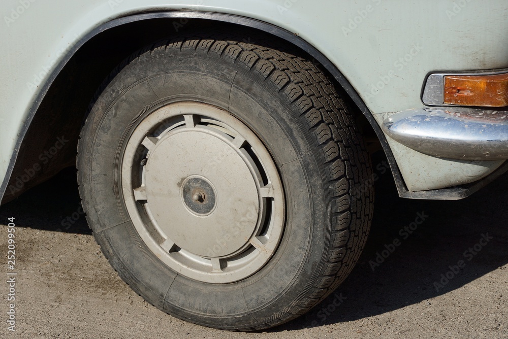 black wheel on a gray car is on the asphalt road black wheel on a gray car is on the asphalt road