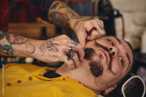 Client during beard shaving in barber shop