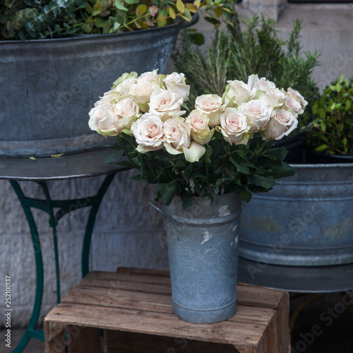 White roses on a stool at the entrance to the flower shop