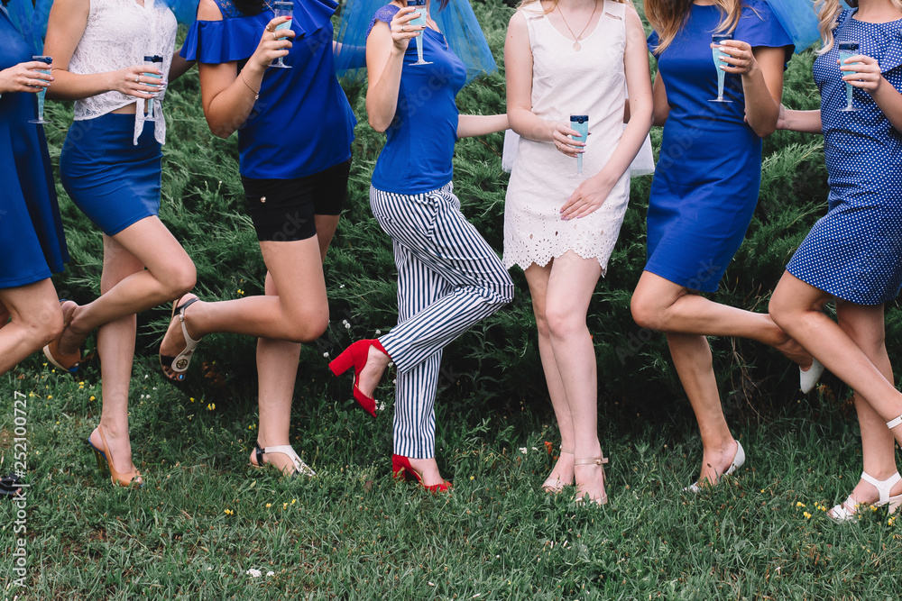 Bachelorette party, girls in blue dresses with glasses of champagne are having fun