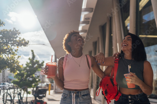 USA, Florida, Miami Beach, two happy female friends having a soft drink in the city