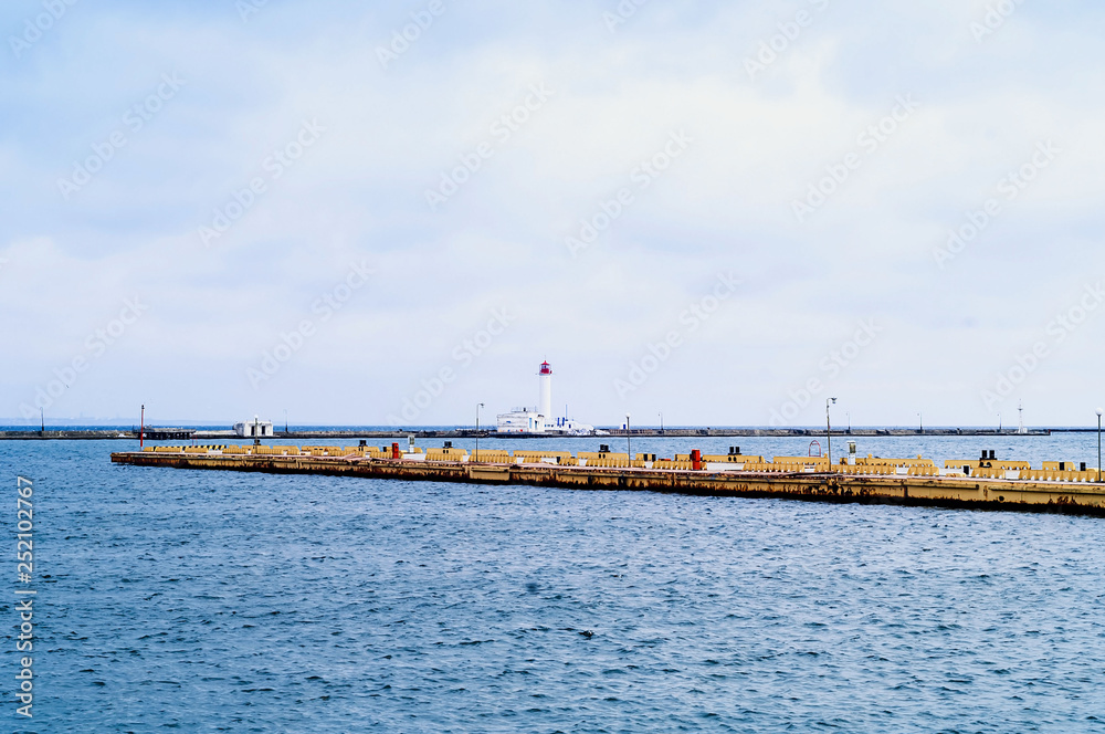 Pier and lighthouse on the background of the sea landscape. Odessa Sea Port.