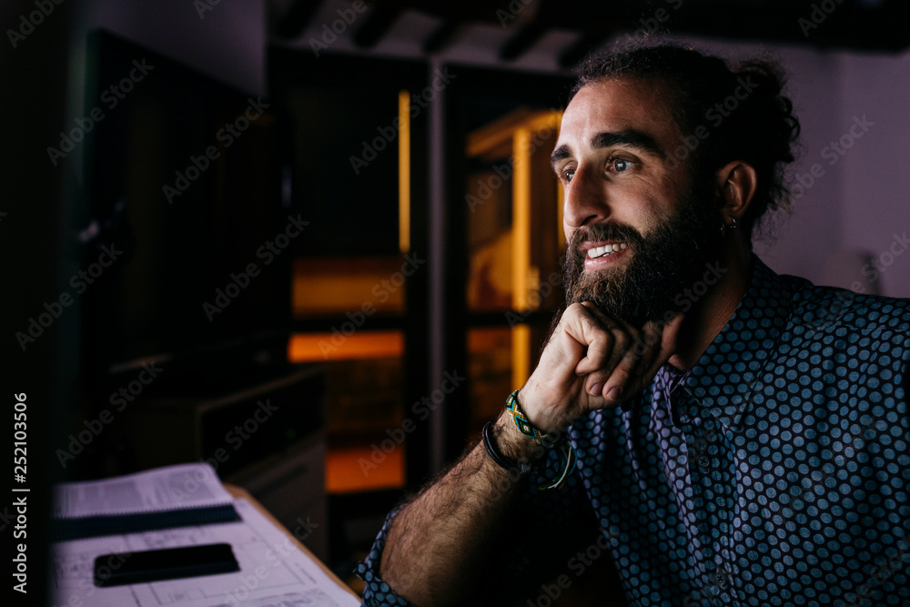 Young man working on a new project at home at night Young man working on a new project at home at night