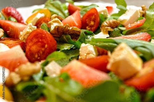 Fresh and healthy salad with fruits, vegetable, rocket and nuts