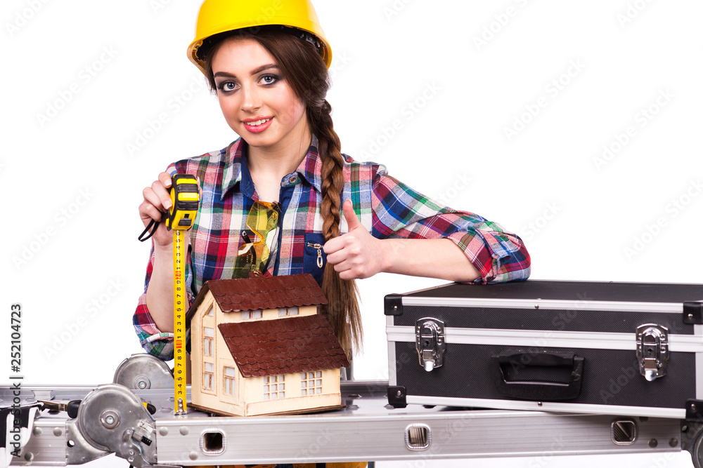Beautiful girl builder is holding a measuring meter Beautiful girl builder is holding a measuring meter