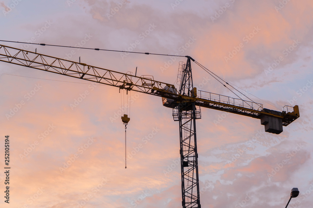 Construction crane over sunset sky
