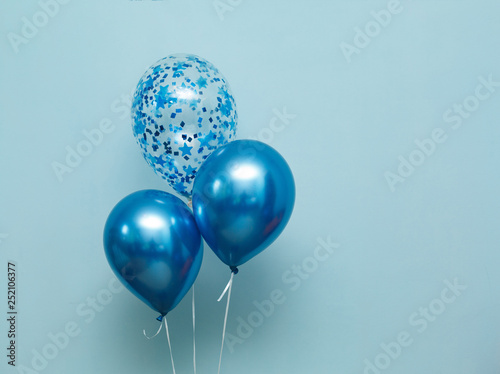 bright matte balloons on a blue background.  three blue inflated balloons. stylish party with balloons. round blue and transparent  balloon. place of celebration