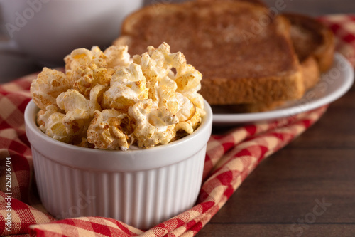 Bowl of Cinnamon Toast Flavored Popcorn on a Wooden Table