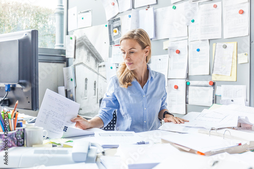 Woman sitting at desk in office doing paperwork photo