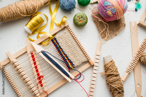 Tools for weaving and thread lie on a white table