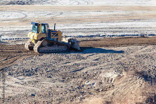 Foto yellow crawler bulldozer rakes the ground
