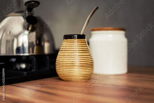 Traditional South American Yerba Mate tea in matero cup with bombilla metal straw servin photographed in modern kitchen photo