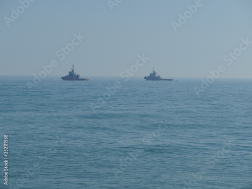 Rimorchiatori in mare per trainare una nave mercantile arenata sulla spiaggia di Bari. Sud Italia