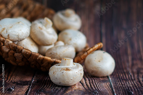 Fresh mushrooms in a basket on a wooden background. Stock photo.