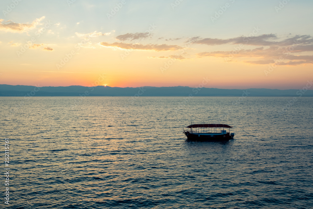 Sunrise over the sea, view of the drifting boat.
