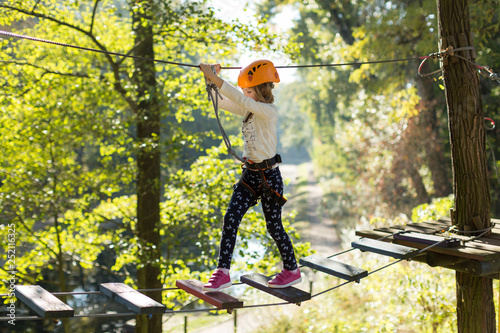 Little girl in ropes course adventure park