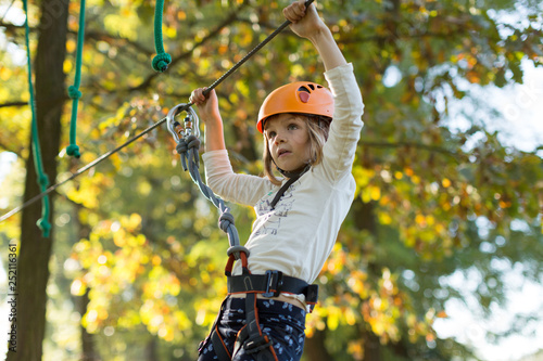 Little girl in ropes course adventure park photo