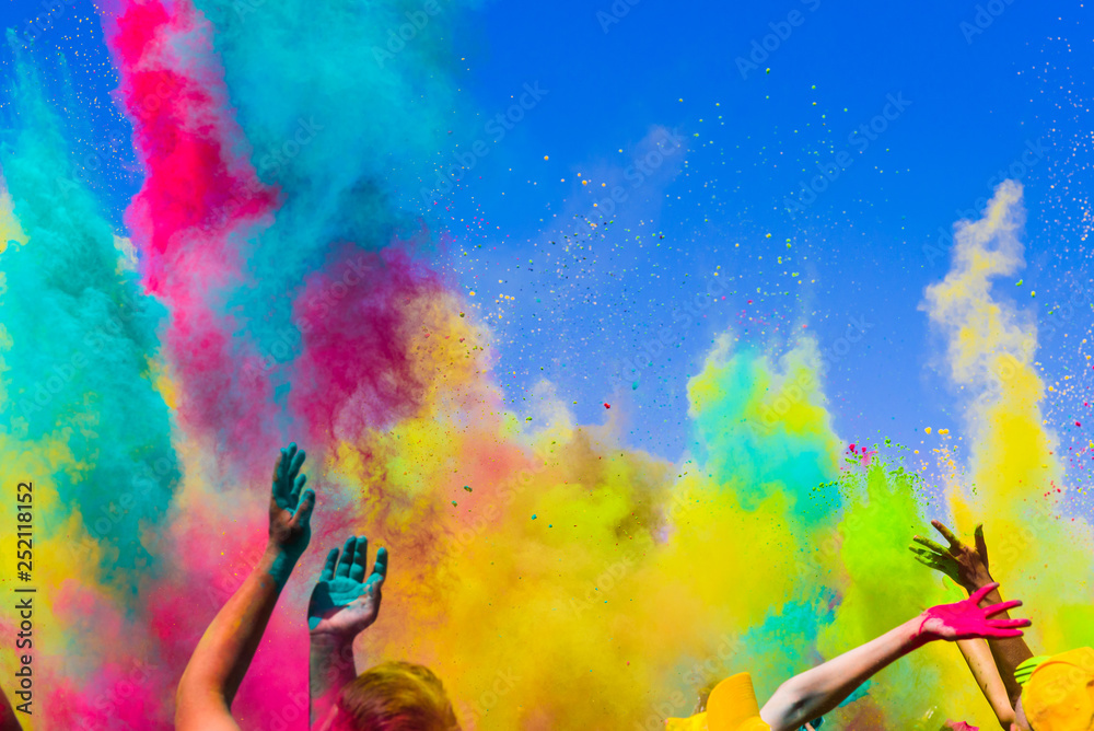 crowd throws colored powder at holi festival - obrazy, fototapety, plakaty 
