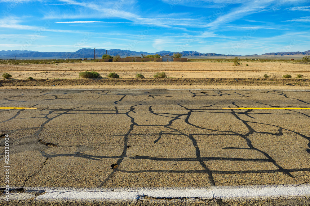 Fototapeta premium Repaired cracks, damaged asphalt on empty freeway through Nevada desert.