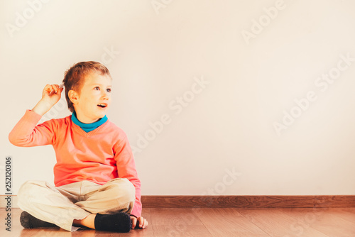 Independent child of 5 years combing himself sitting on the floor of his house