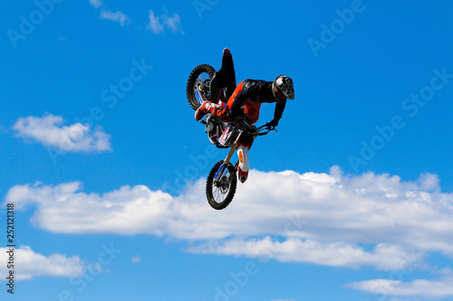 JERSEY CITY, NJ - AUGUST 13, 2015: An unknown freestyle motocross rider soars through the air performing high-flying stunts on a motorcycle in Liberty State Park. The extreme sport is also called FMX. photo