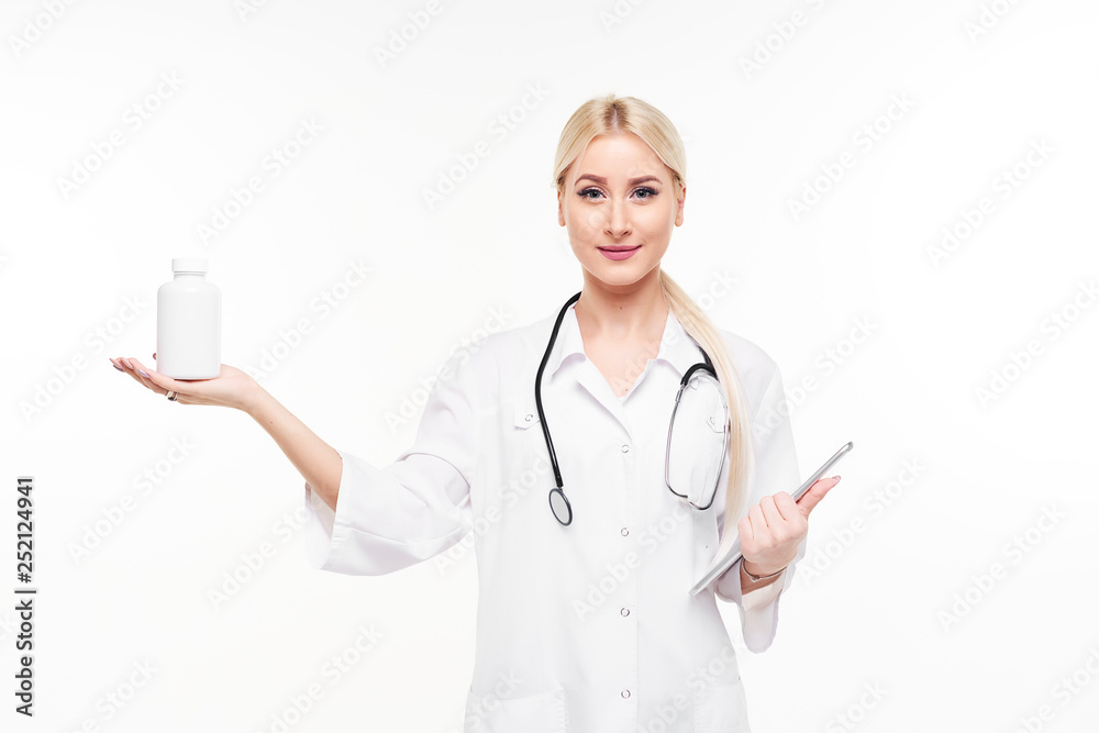 Attractive young female doctor with stethoscope pointing at white pill bottle isolated on white background Attractive young female doctor with stethoscope pointing at white pill bottle isolated on white background