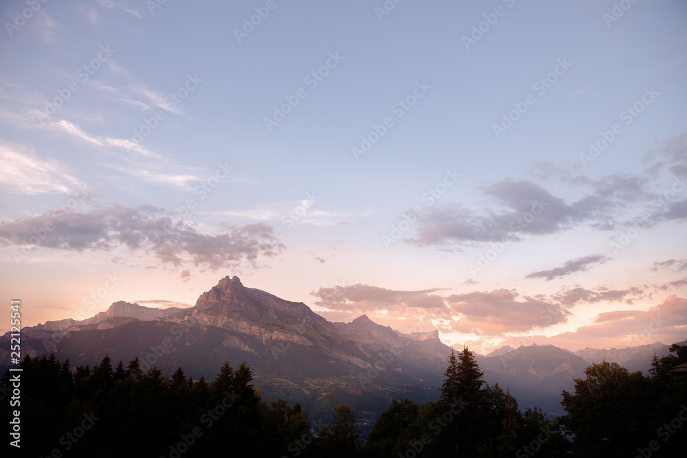 Dawn Alps mountains France, snowy peaks in fog, summer sunset