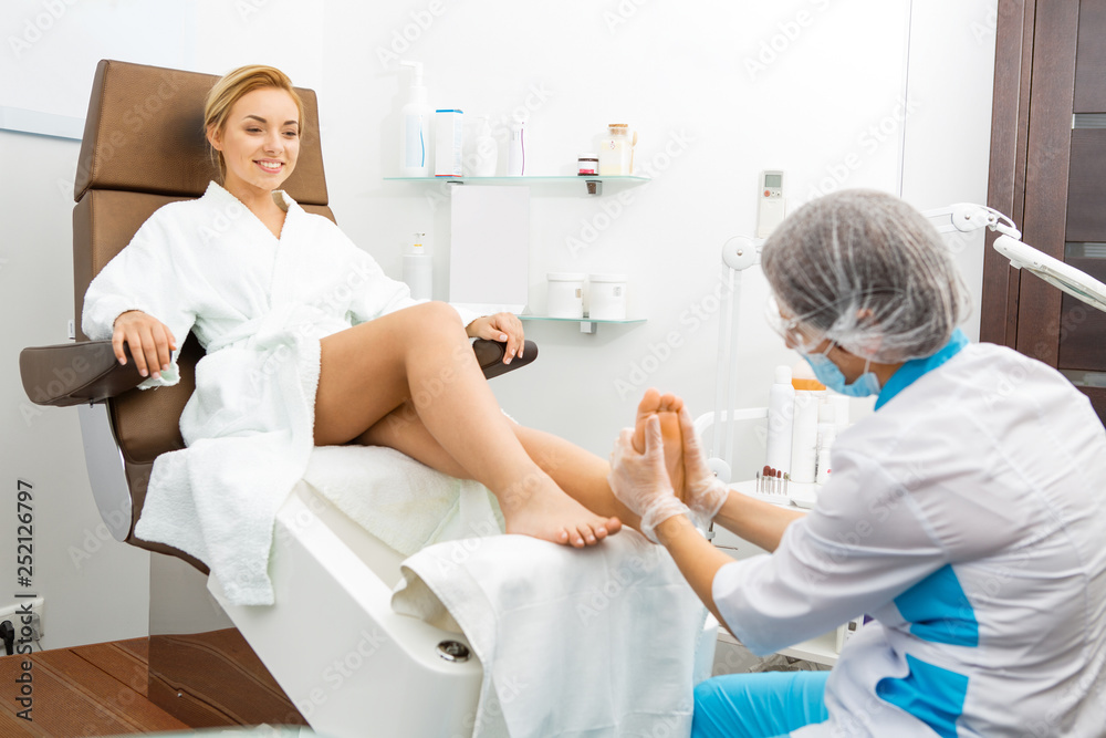 Professional pedicurist working at the salon Professional pedicurist working at the salon