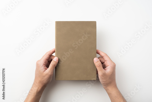 man hand hold brown notebook on white background