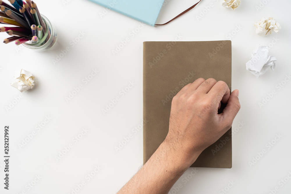 Obraz premium man hand hold brown notebook on white background
