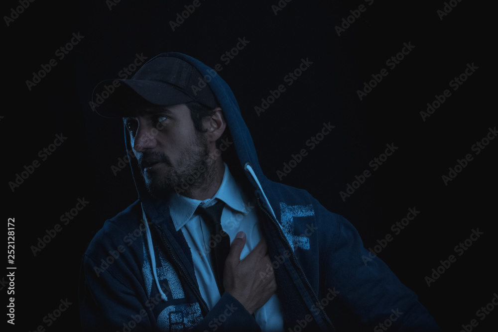 portrait with black background of a young man in cap shirt and tie portrait with black background of a young man in cap shirt and tie