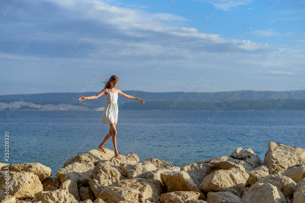 Croatia, Lokva Rogoznica, girl balancing barefoot on rocks Croatia, Lokva Rogoznica, girl balancing barefoot on rocks