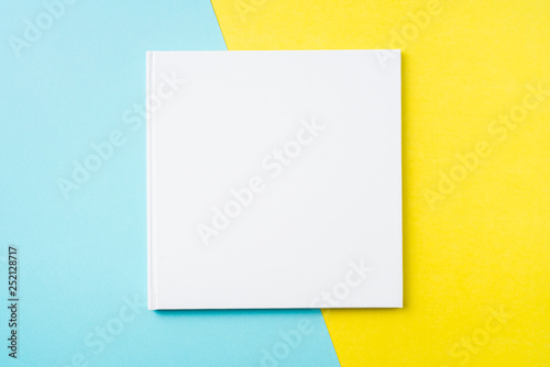 white square notebook on yellow and blue paper